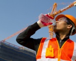 How should heavy workers drink water properly